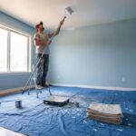 Peinture mur plafond : bricoleur peignant un plafond au rouleau avec manche télescopique